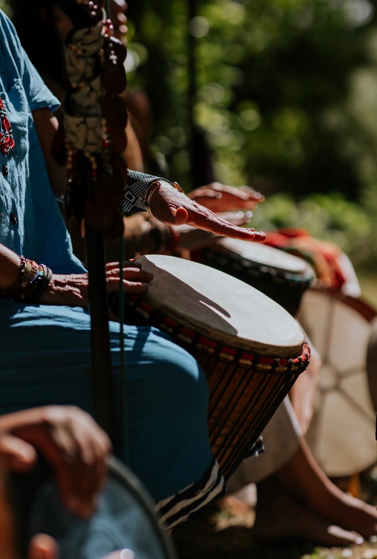 Hands playing a djembe drum during a group ceremony