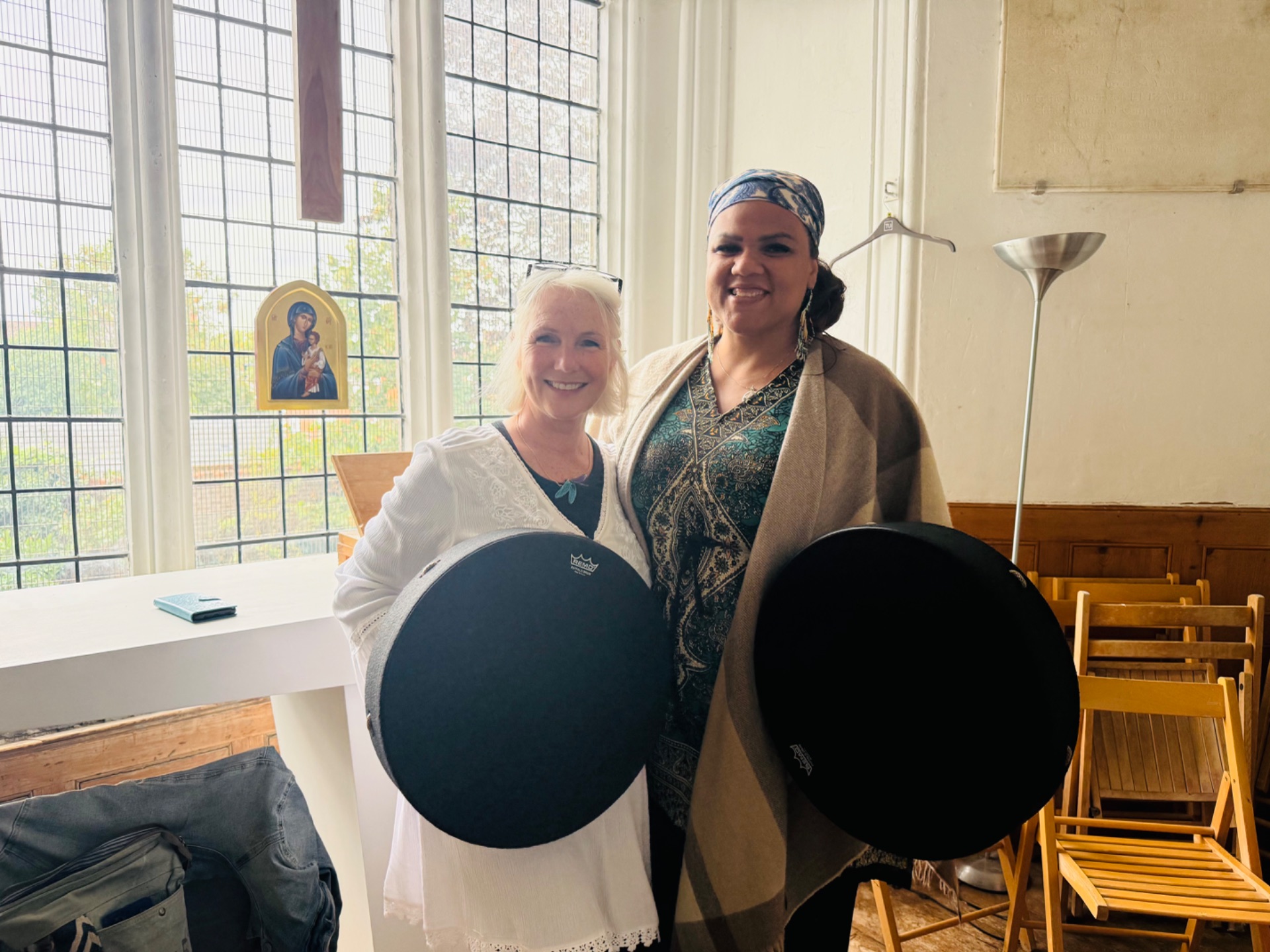 Two women holding frame drums in the hall at Highgate United Reformed Church