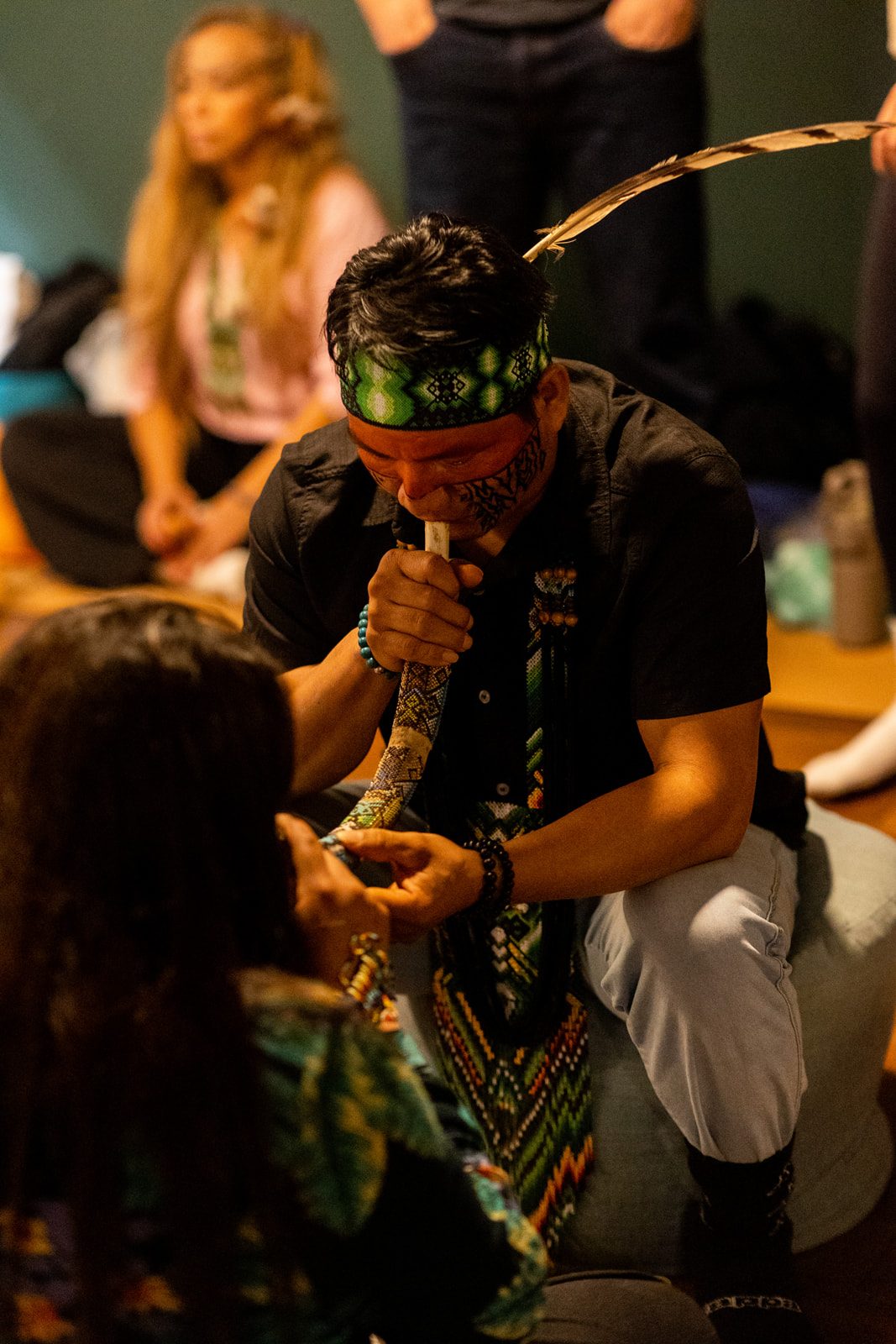 Hape being offered with a ceremonial pipe during a group ceremony