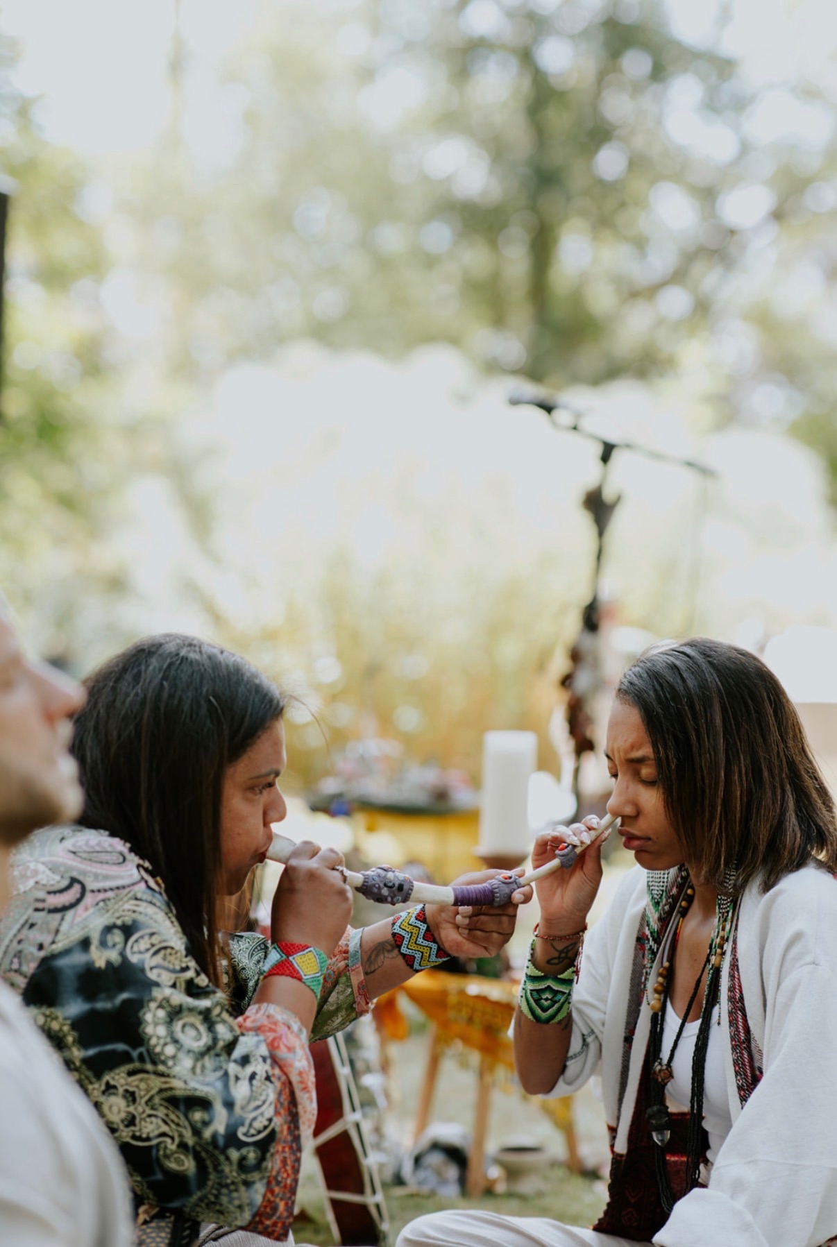 Hape shared between two guests beside a candlelit outdoor altar